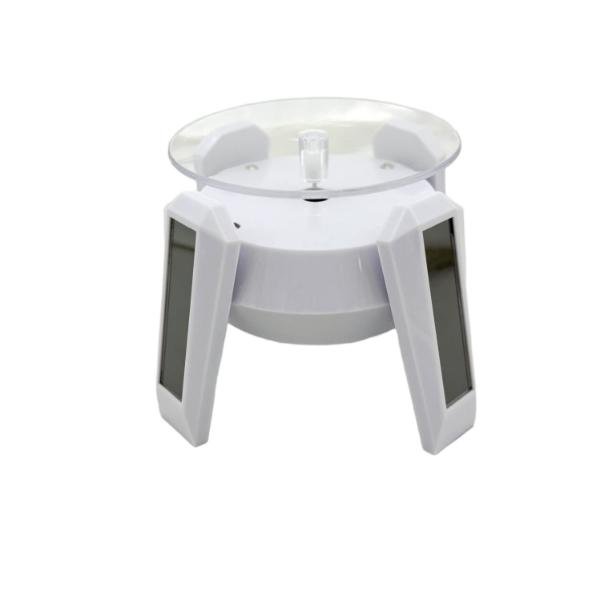 Solar powered rotating display stand with transparent acrylic turntable and black base for 360-degree product display.